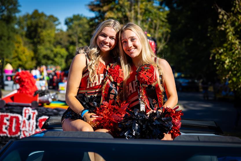 Two cheerleaders smile